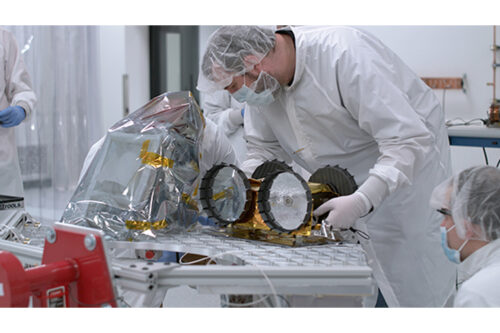 Tim Angert, manager of the machine shop inside Carnegie Mellon University's Robotics Institute, places Iris on the payload deck during the rover’s hardware integration on Wednesday, December 1, 2021, inside the clean room at Astrobotic’s headquarters in Pittsburgh.