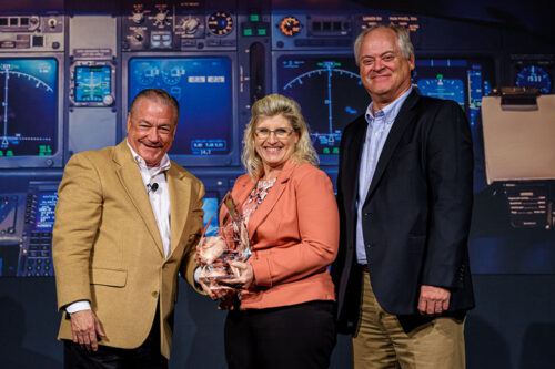 Spirit AeroSystems Vice President for Research and Technology Cindy Hoover accepts the 2021 SME Award for Excellence in Composites Manufacturing (Large Company) Award from Michael Packer, President of the Board of Directors for SME. At right is Blaise Bergmann, Spirit AeroSystems Ultracompetitive Composite Distinctive Capability Leader and Technical Fellow.