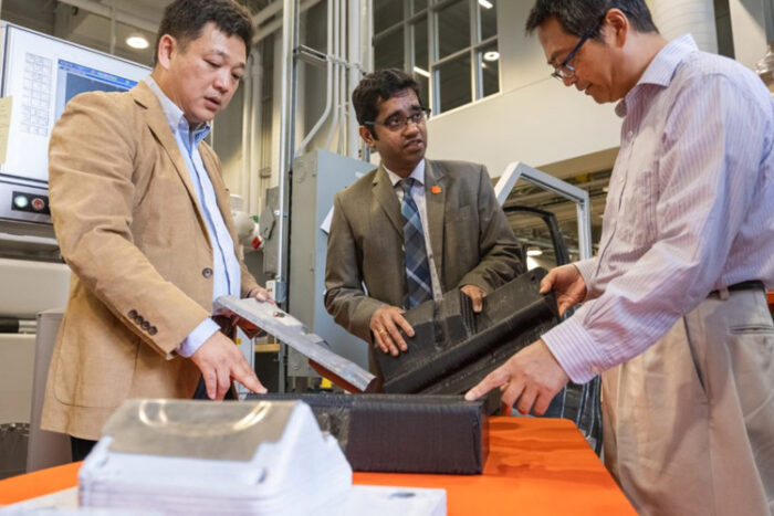 Srikanth Pilla, center, talks about manufacturing tools with Gang Li, left, and Feng Luo.