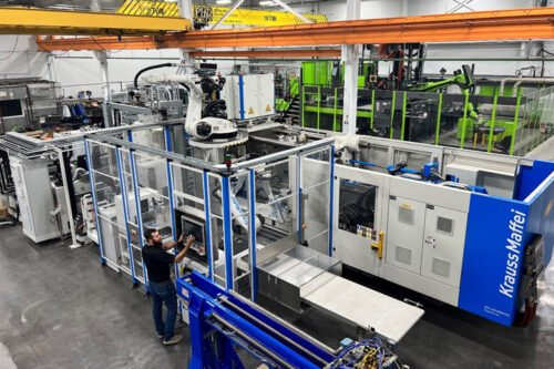 Tomas Lorik, ATLAS operations manager for quality assurance, inspects hybrid thermo-forming and injection molding equipment at ATLAS.